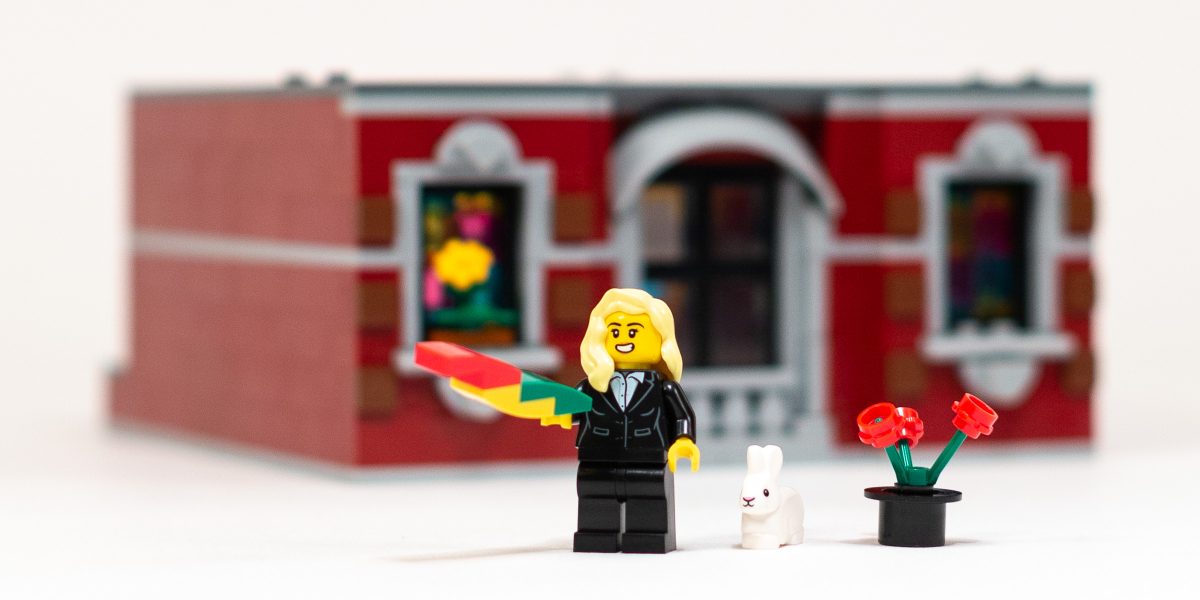 Magician standing in front of the intricately detailed front facade.