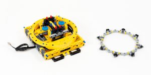 Large four-part gear with a ring of wheels functioning as bearings.