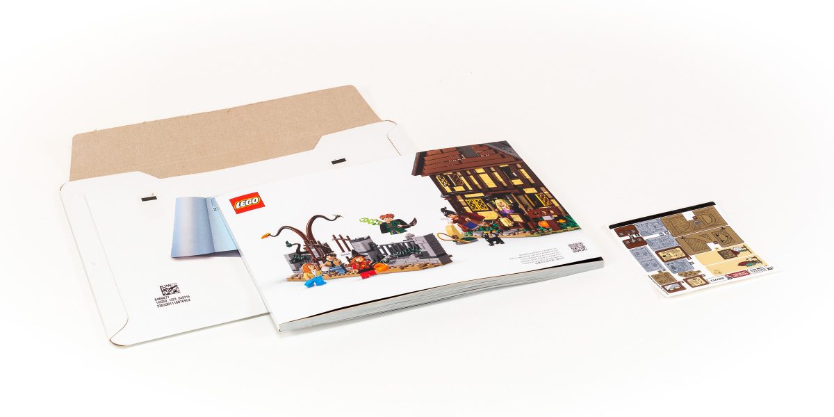 The large instruction booklet and sticker sheet come in a protective cardboard sleeve.