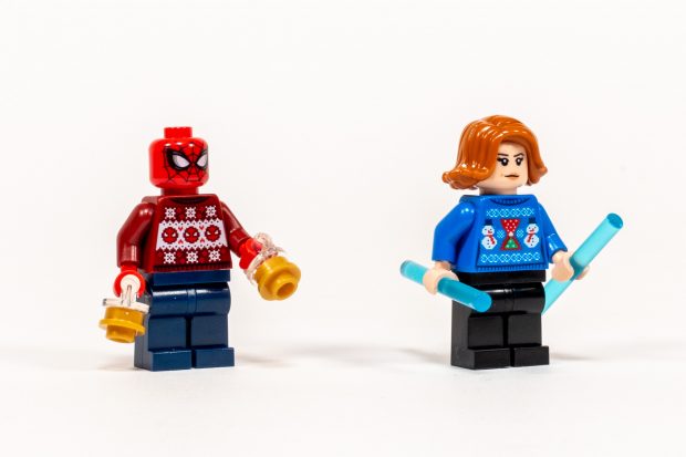Spiderman and Black Widow wearing festive holiday sweaters.