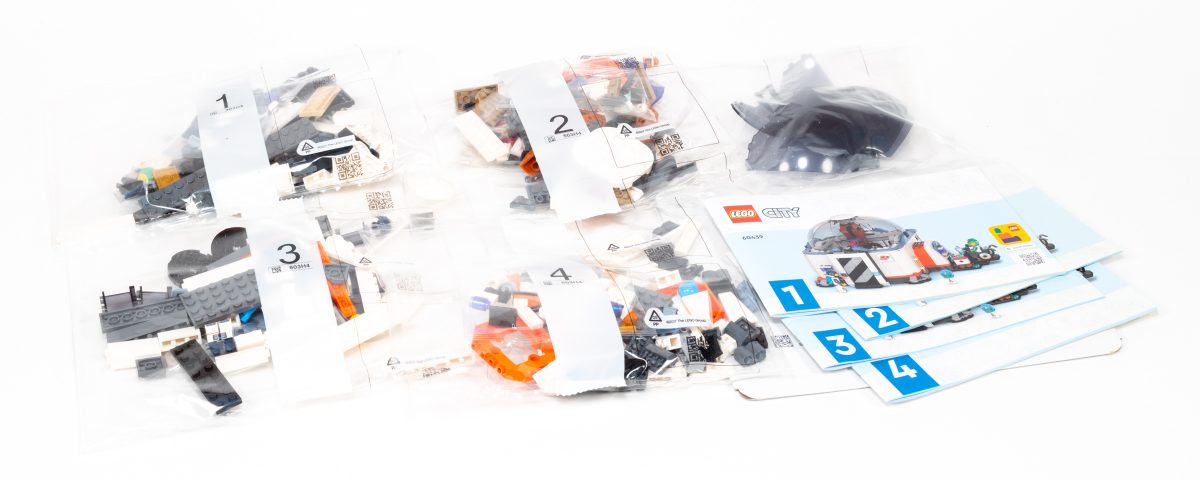 The box contains four numbered stages and four instruction booklets.