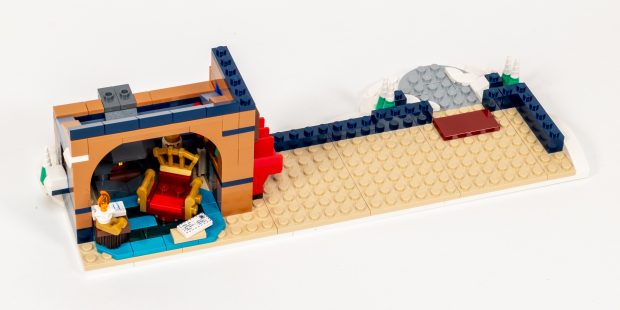 The interior includes a fancy chair, bookshelf, and table.