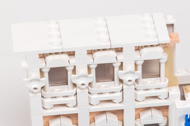 Upper windows with a row of clips beneath the cornice.