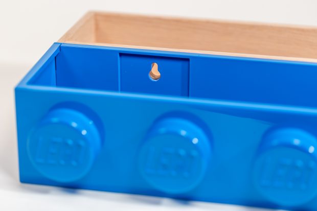 The holes used to attach the wooden or plastic Book Rack to a wall are in the same position.